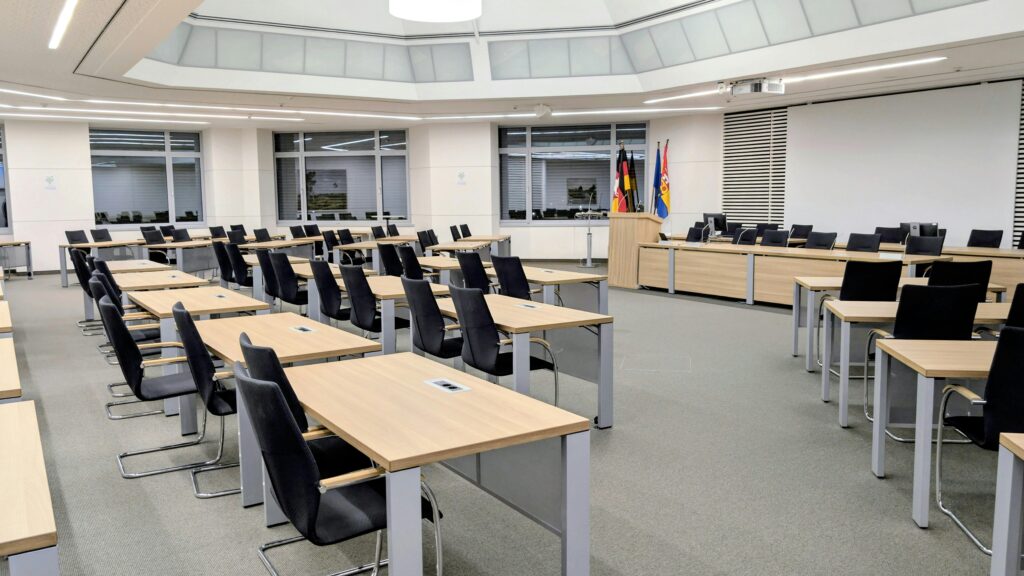 Spacious and modern meeting room in Niedersachsen, Germany, with desks and flags.